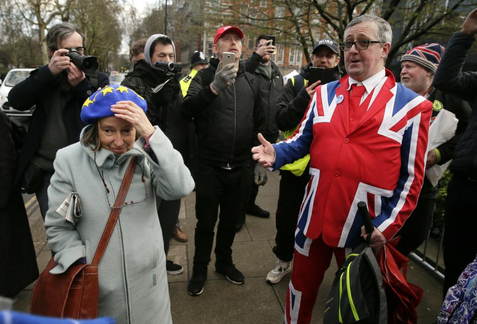 An anti-Brexit, left, and pro-Brexit supporter debate outside the House of Parliament in London, Tuesday, March 12, 2019. Prime Minister Theresa May's mission to secure Britain's orderly exit from the European Union appeared headed for defeat Tuesday, as lawmakers ignored her entreaties to support her divorce deal and end the political chaos and economic uncertainty that Brexit has unleashed.(AP Photo/Tim Ireland)