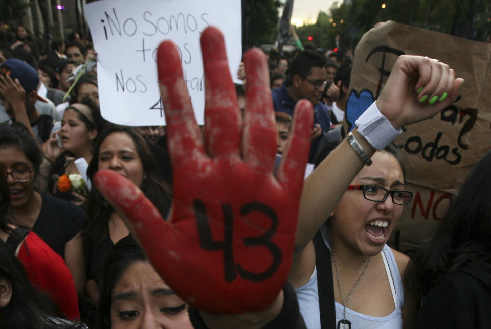 FIE - In this Oct. 22, 2014 file photo, peopole protest the disappearance of 43 students in Mexico City. Mexican President Enrique Pena Nieto has again on Wednesday, Aug. 29, 2018, defended the widely criticized original investigation of the disappearance of the 43 students, but concedes that his administration has failed to bring the country peace. (AP Photo/Marco Ugarte, File)