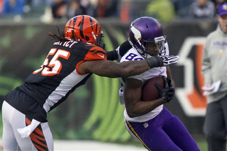Dec 22, 2013; Cincinnati, OH, USA; Minnesota Vikings wide receiver Cordarrelle Patterson (84) catches the ball and is tackled by Cincinnati Bengals outside linebacker Vontaze Burfict (55) in the third quarter of the game at Paul Brown Stadium. Cincinnati Bengals beat the Minnesota Vikings by the score of 42-14. Mandatory Credit: Trevor Ruszkowksi-USA TODAY Sports