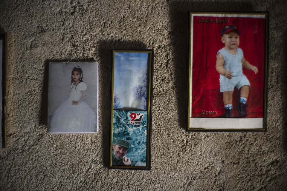 The grandchildren of Rosa Lopez hang in her living room, alongside a photo of Fidel Castro in Mariel, Cuba, Thursday, May 18, 2023. Lopez, a 59-year old housewife, uses a coal stove to cook for her grandchildren, as the gas cylinders she normally uses to cook her meals have not been available for a month and a half in Mariel. (AP Photo/Ramon Espinosa)