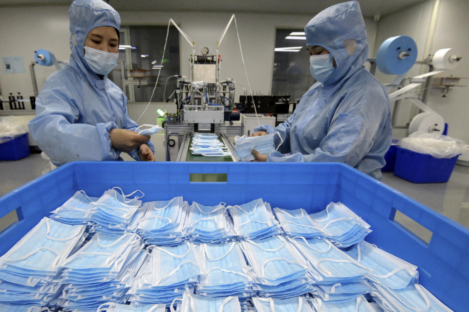 Workers wearing face masks to help curb the spread of the coronavirus arrange face masks from a machine at a factory in Handan city in north China's Hebei province on Jan. 8, 2021. China's economy grew 2.3% in 2020 as a recovery from the coronavirus pandemic accelerated while the United States, Europe and Japan struggled with disease flare-ups. (Chinatopix via AP)