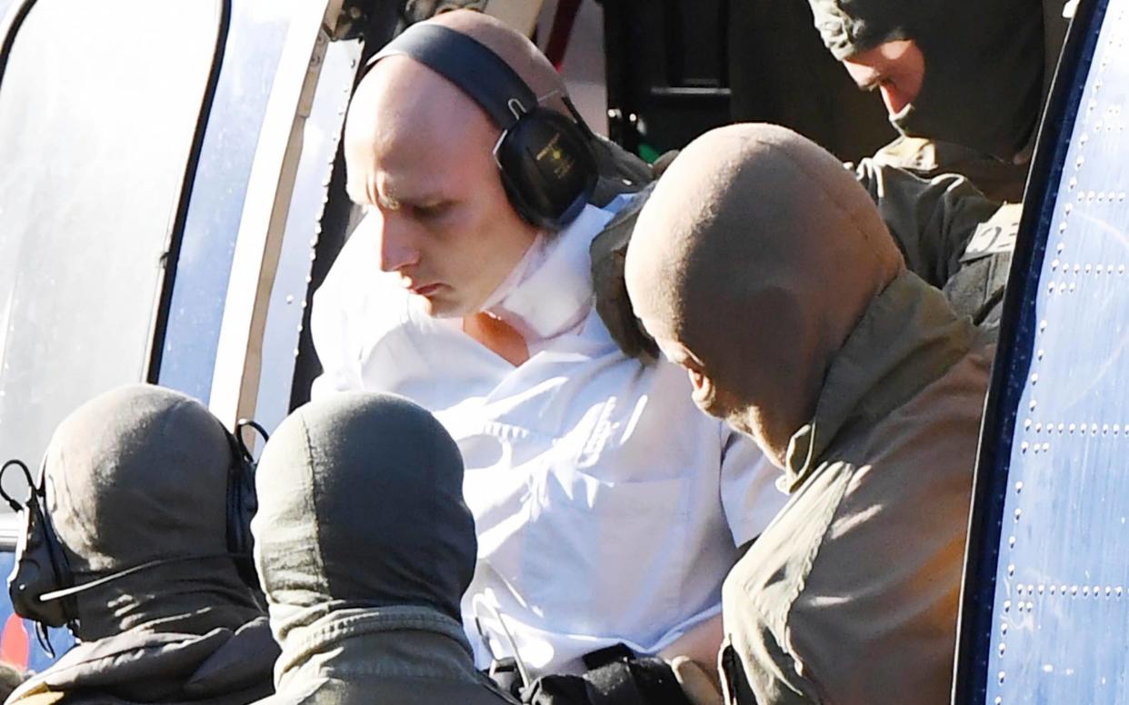 Stephan Balliet in a white overall is escorted by Police officers as he arrives at the federal prosecutor's office in Karlsruhe - AP