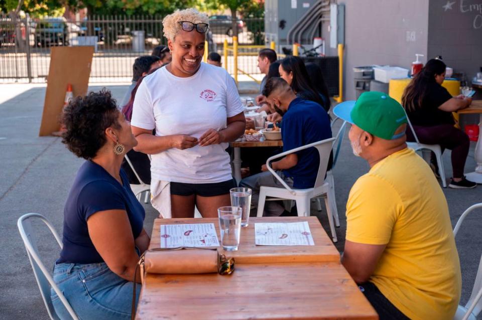 Jim-Denny’s owner N’Gina Guyton talks with customers Wednesday in the new spacious outdoor dining area.