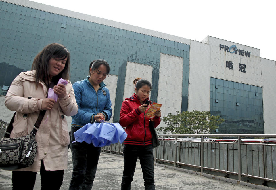 FILE - In this Feb. 16, 2012 file photo, workers walk on a footbridge outside the Proview Technology office building in Shenzhen, in southern China's Guangdong province. The battle between the ailing Chinese electronics maker and Apple Inc. over the iPad name is just as much a tale of obsolescence in the fast-moving global technology industry as it is a legal row over a trademark. (AP Photo/File) CHINA OUT