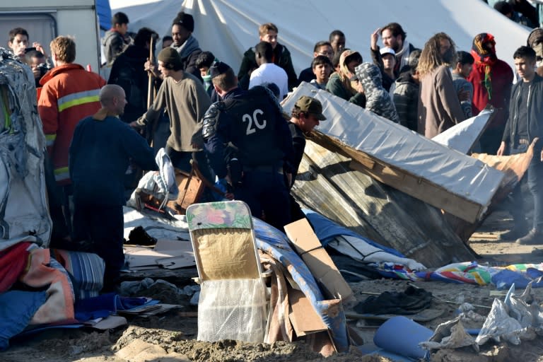 French riot police look on as workers begin the demolition of the "Jungle" migrant camp, in Calais, northern France, on October 25, 2016