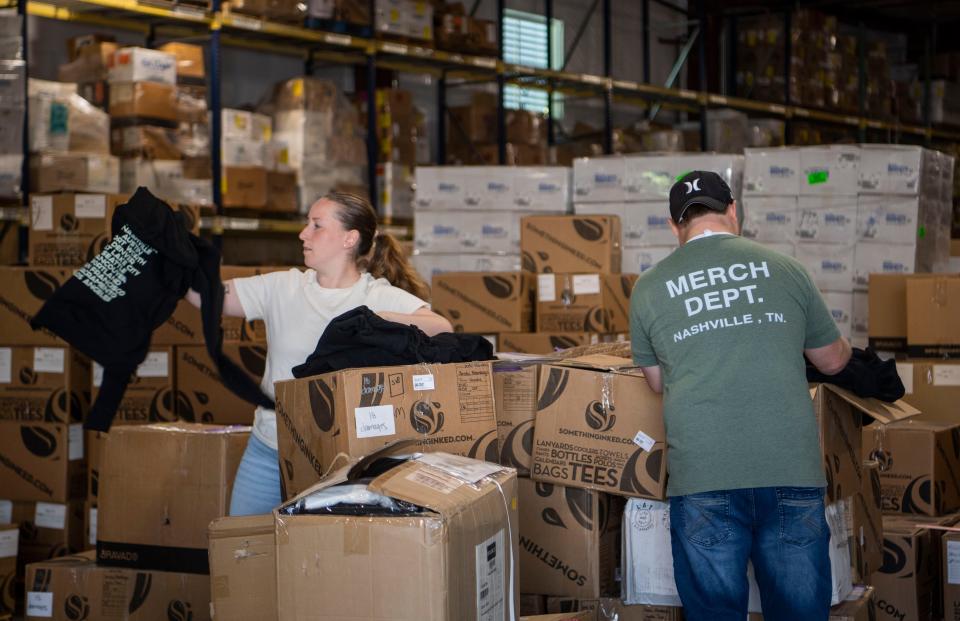 Hannah Valdez and Matt Allen check the merchandise at the Something Inked warehouse in Nashville, Tenn., Tuesday, Oct. 3, 2023.