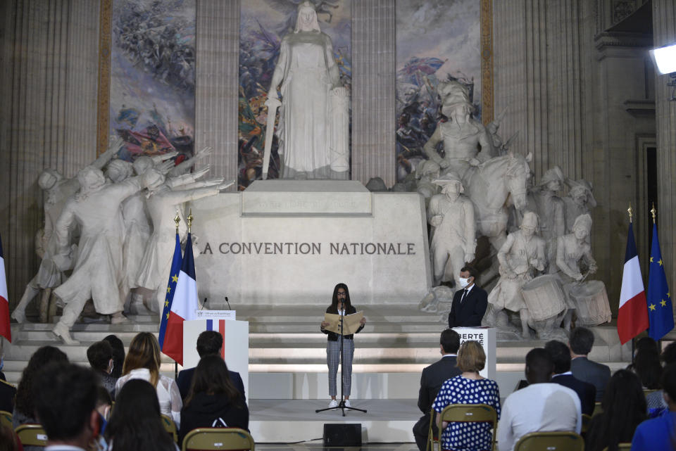 French President Emmanuel Macron, right, listens to a young girl delivering her speech during a ceremony to celebrate the 150th anniversary of the proclamation of the Republic, at the Pantheon monument, Friday Sept.4. 2020 in Paris. (Julien de Rosa, Pool via AP)