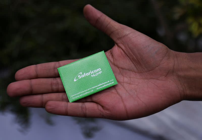 FILE PHOTO: A customer displays the package of a Safaricom Ethiopia sim card during the service launch in Addis Ababa