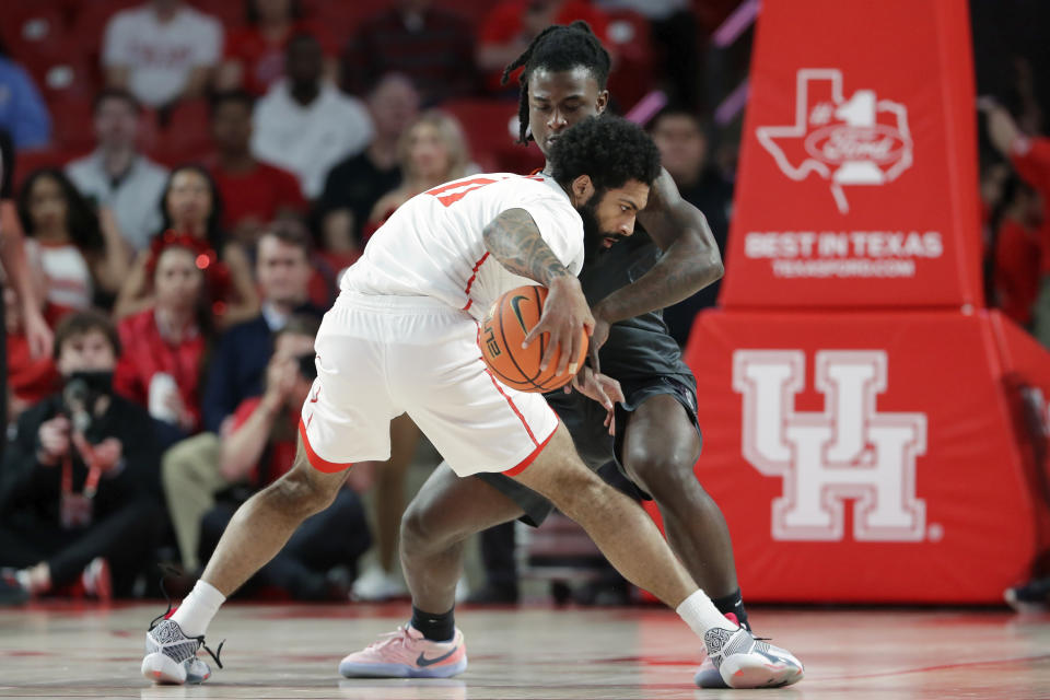 Houston guard Damian Dunn, front, drives into Oklahoma State guard Jamyron Keller, back, during the first half of an NCAA college basketball game Tuesday, Feb. 6, 2024, in Houston. (AP Photo/Michael Wyke)