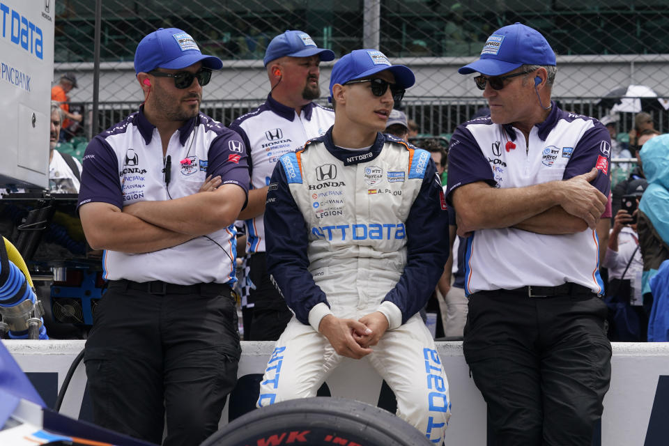 FILE - Alex Palou, of Spain, talks with crew before the final practice for the Indianapolis 500 auto race at Indianapolis Motor Speedway, Friday, May 27, 2022, in Indianapolis. There is no love lost between rival team owners Chip Ganassi and Zak Brown, and the two now find themselves entangled over the reigning IndyCar champion. Ganassi says he picked up the option on Alex Palou for 2023, but McLaren Racing says it has signed the Spaniard for next year.(AP Photo/Darron Cummings, FIle)