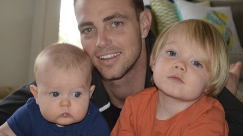 The beloved dad holding two of his boys.