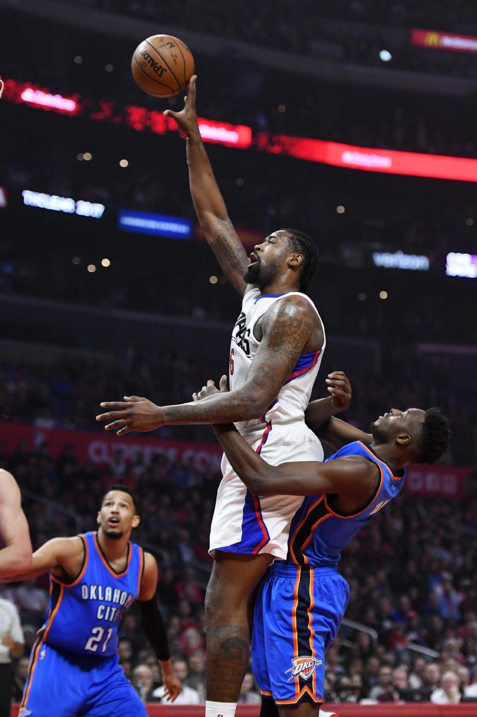 Los Angeles Clippers center DeAndre Jordan, center, shoots as Oklahoma City Thunder forward Jerami Grant, right, defends a long with forward Andre Roberson during the first half of an NBA basketball game, Monday, Jan. 16, 2017, in Los Angeles. (AP Photo/Mark J. Terrill)