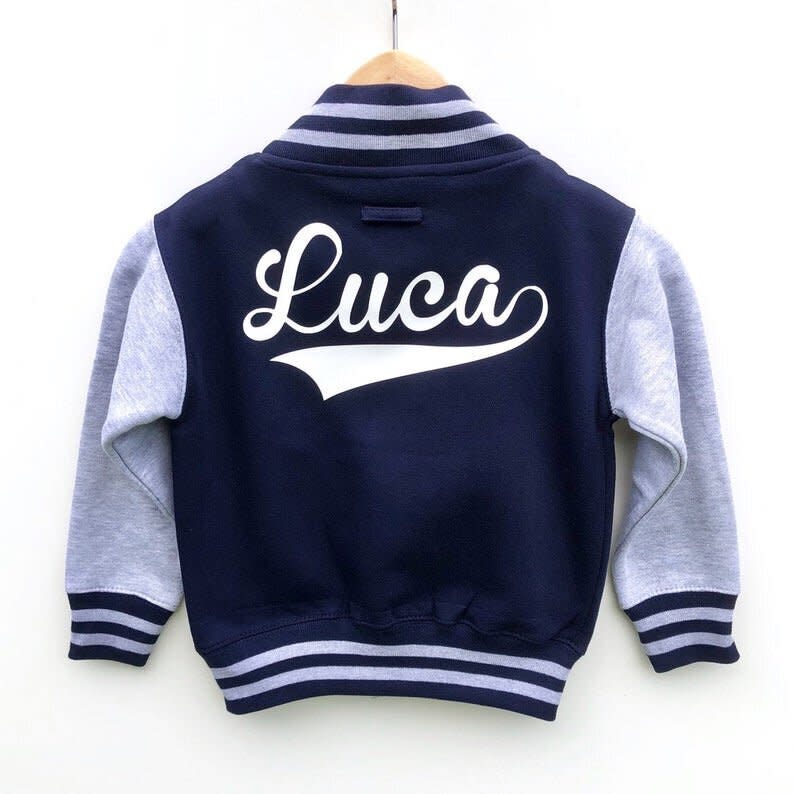 This varsity jacket comes in three classic colors and can be customized with your kiddo's name or nickname. <strong><a href="https://fave.co/2ZRcjCk" target="_blank" rel="noopener noreferrer">Originally $32, get it for up to 20% off during Etsy's Back-To-School Sale</a>.</strong>