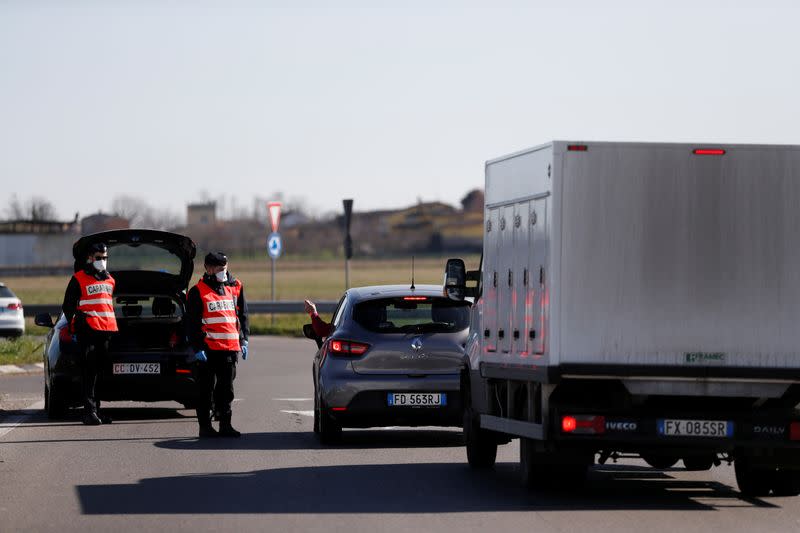 Members of the Italian Carabinieri guard the entrance of the red zone of Casalpusterlengo