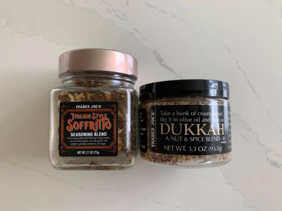 Two jars of Trader Joe's soffritto and dukkah on a marble countertop.