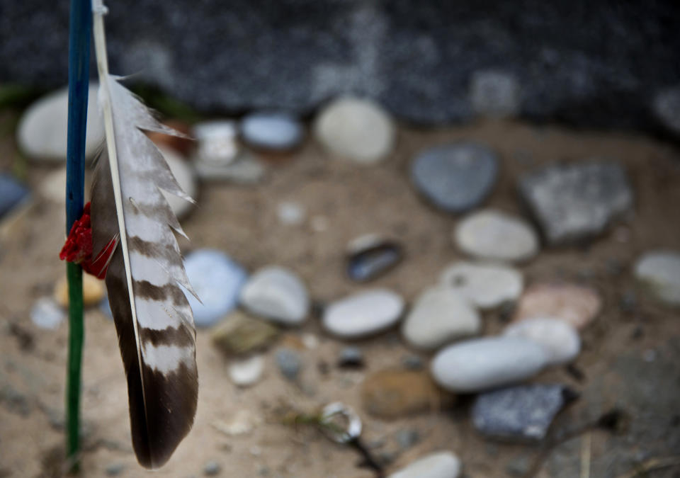 In this May 1, 2019 file photo, a feather and stones are left at the Charles Shay Memorial at Omaha Beach in Saint-Laurent-sur-Mer, Normandy, France. Instead of parades, remembrances, embraces and one last great hurrah for veteran soldiers who are mostly in their nineties to celebrate VE Day, it is instead a lockdown due to the coronavirus, COVID-19. (AP Photo/Virginia Mayo, File)