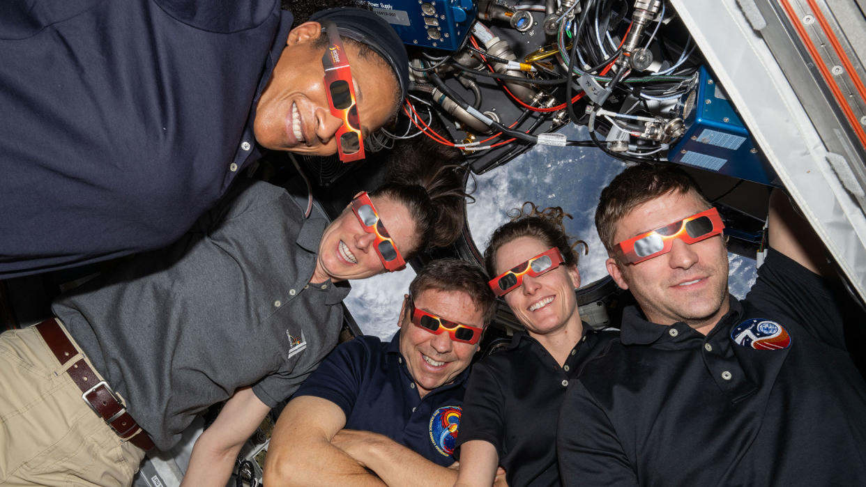  Expedition 70 crew members Jeanette Epps, Tracy Dyson, Michael Barratt, Loral O'Hara and Oleg Kononenko model eclipse glasses ahead of the April 8 total solar eclipse over North America. 