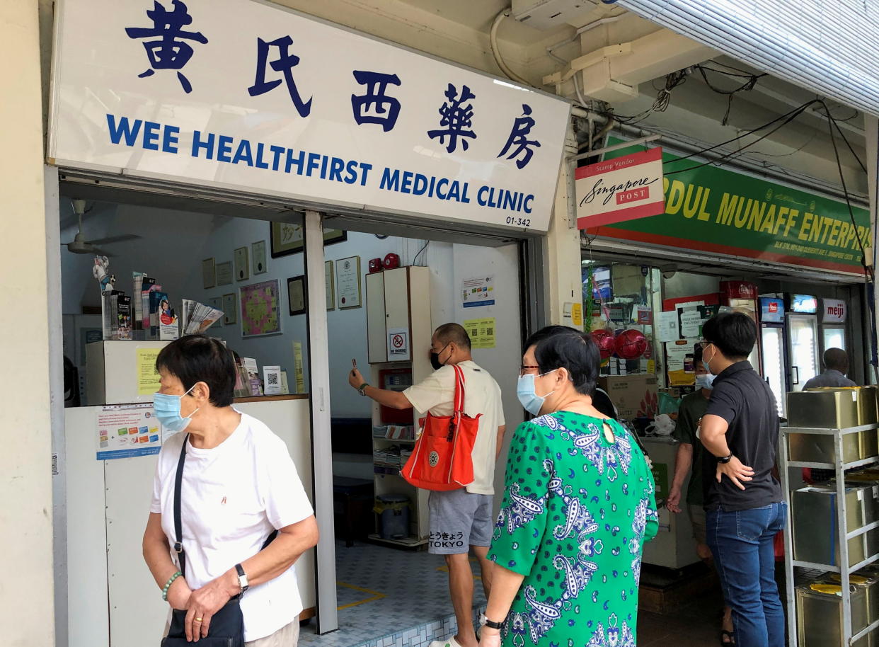 Mask-wearing public outside a general practitioner clinic in Singapore. 