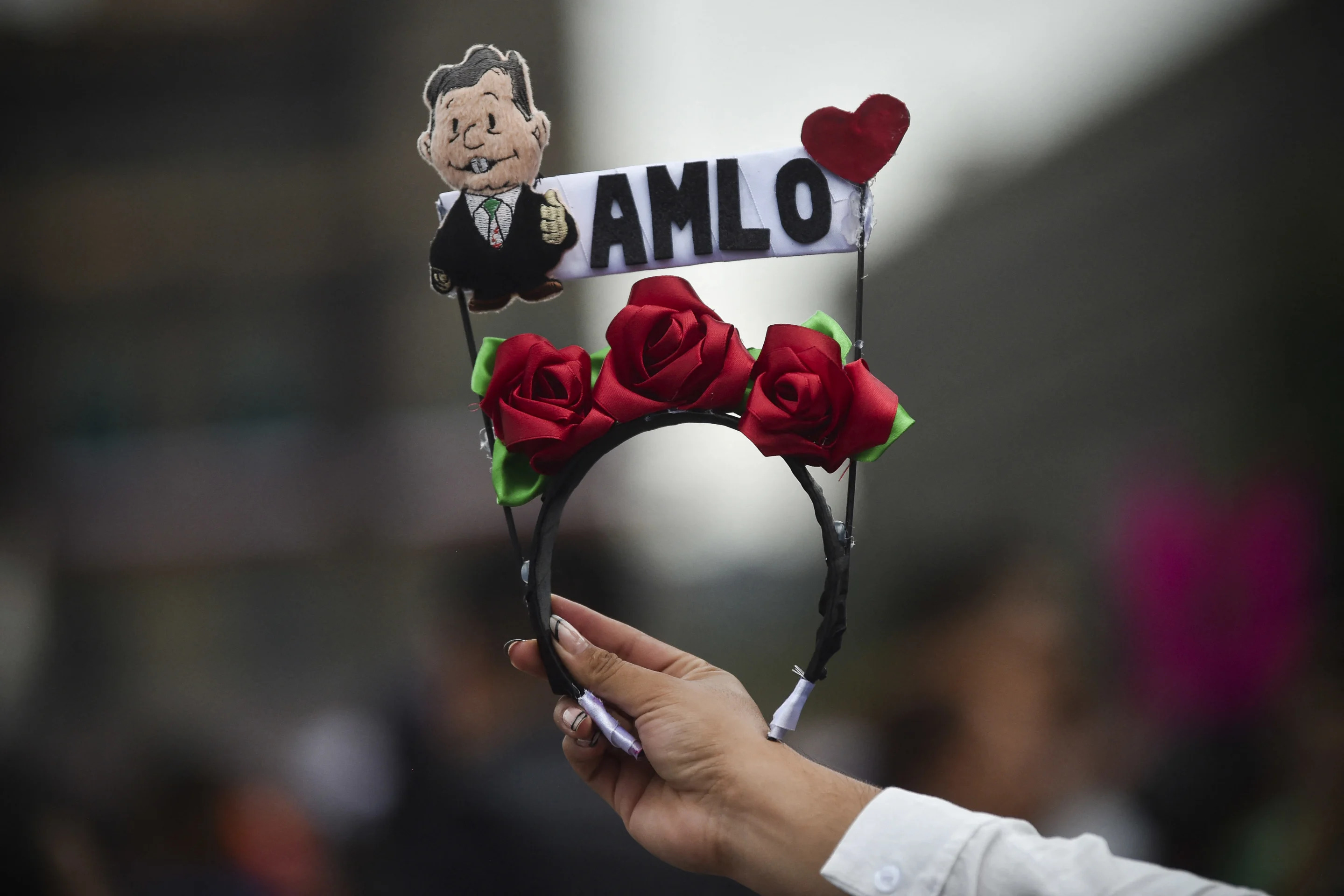 Un vendedor vende tiaras adornadas con flores y un muñeco que representa al presidente mexicano Andrés Manuel López Obrador durante la ceremonia del 'Grito de Independencia', que marca el inicio de las celebraciones del Día de la Independencia en la Plaza El Zócalo de la Ciudad de México el 15 de septiembre de 2024. (RODRIGO OROPEZA/AFP via Getty Images)