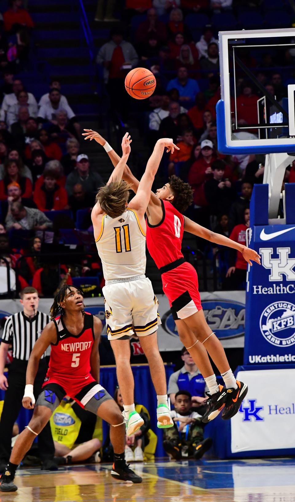 Newport's Taylen Kinney (0) rejects the jump shot of  Lyon County's Travis Perry at the KHSAA Sweet 16 state basketball tournament, March 16, 2023.