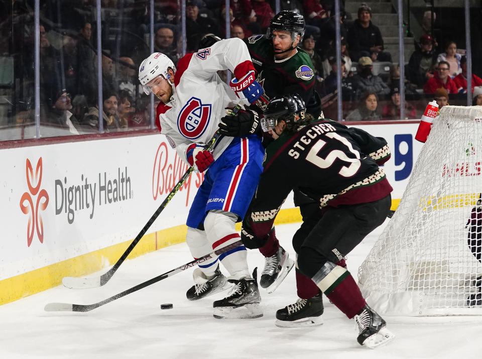 Montreal Canadiens' Joel Armia (40) gets sandwiched between Arizona Coyotes' Patrik Nemeth, middle, and Troy Stecher (51) in the second period during an NHL hockey game, Monday, Dec. 19, 2022, in Tempe, Ariz. (AP Photo/Darryl Webb)