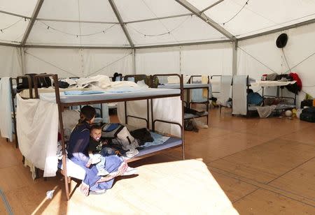 Asylum seekers resting on bunk beds at a refugee tent camp called 'The Tent' in Munich October 10, 2014. REUTERS/Michaela Rehle