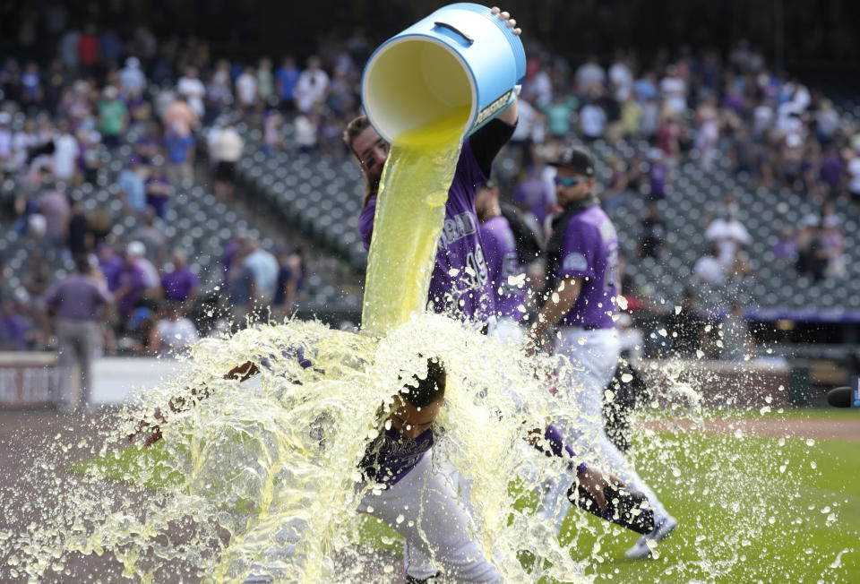 Colorado Rockies' Charlie Blackmon, back, douses Elias Diaz, who drove in the tying and winning runs off Chicago White Sox relief pitcher Kendall Graveman in the ninth inning of a baseball game Wednesday, July 27, 2022, in Denver. (AP Photo/David Zalubowski)