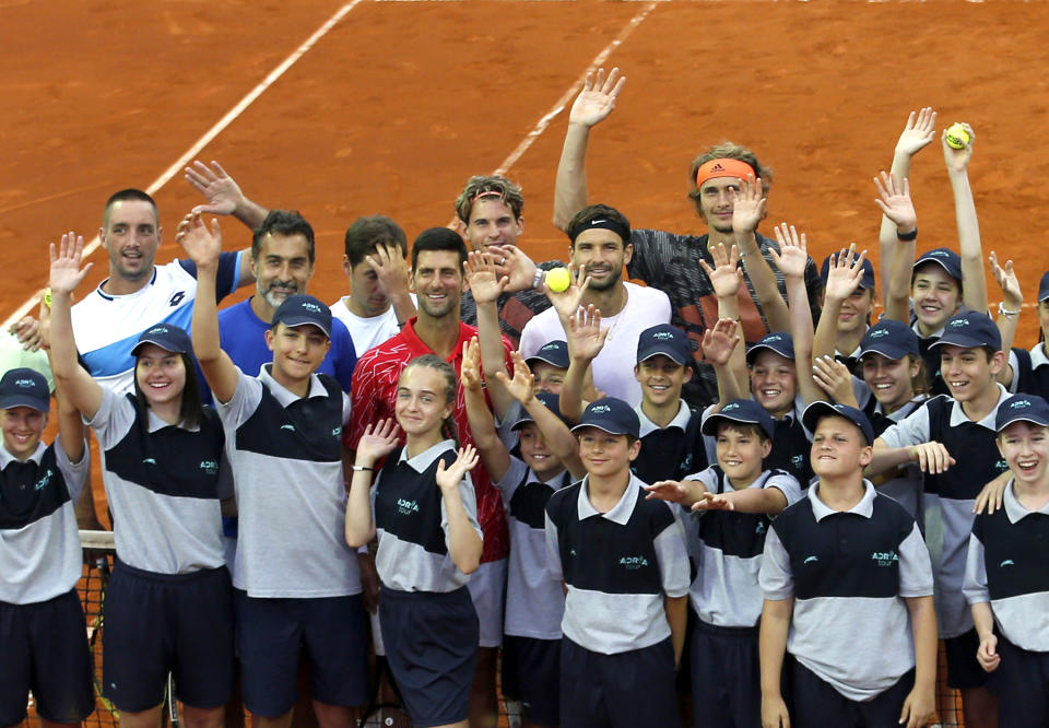 En esta foto del viernes 12 de junio de 2020, Novak Djokovic (centro) posa con voluntarios y jugadores durante la gira de exhibición Adria Tour en Belgrado, Serbia. (AP Foto/Darko Vojinovic)