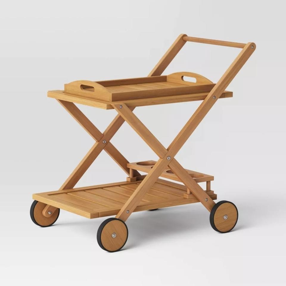 Wooden serving cart on wheels with two tiers and a handle