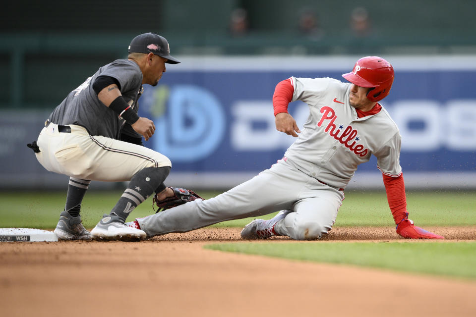 Philadelphia Phillies' J.T. Realmuto, right, is caught trying to steal second as he is tagged out Washington Nationals second base Ildemaro Vargas, left, during the sixth inning of a baseball game, Saturday, April 6, 2024, in Washington. (AP Photo/Nick Wass)