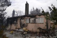 A burnt house after a wildfire in Drosopigi village, about 28 kilometres (27 miles) north of Athens, Greece, Friday, Aug. 6, 2021. Thousands of residents of the Greek capital have fled to safety from a wildfire that burned for a fourth day north of Athens as crews battle to stop the flames reaching populated areas, electricity installations and historic sites. (AP Photo/Thanassis Stavrakis)