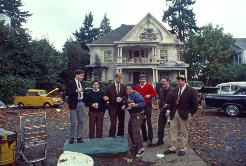 a vintage photo of boys posing in front of a frat house