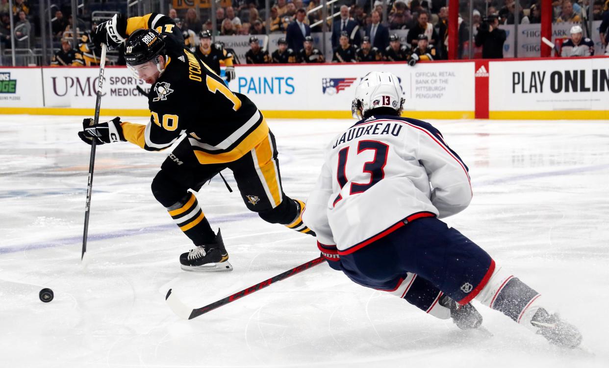 Mar 28, 2024; Pittsburgh, Pennsylvania, USA; Pittsburgh Penguins left wing Drew O'Connor (10) handles the puck as Columbus Blue Jackets left wing Johnny Gaudreau (13) defends during the first period at PPG Paints Arena. Mandatory Credit: Charles LeClaire-USA TODAY Sports