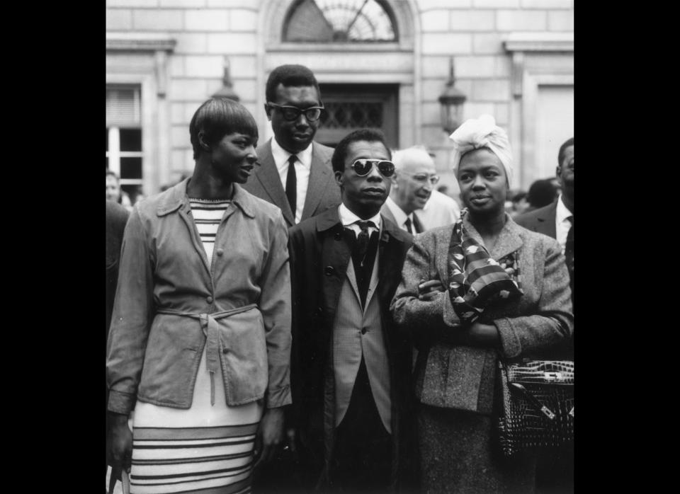 Author and playwright James Baldwin (1924 - 1987), wearing sunglasses, stands between May Mercier (L) and pianist and singer Hazel Scott (R), while pianist and composer Memphis Slim (1915 - 1988) stands behind them, at a public demonstration supporting the civil rights 'March on Washington,' on Aug. 21, 1963 in Paris, France.  (RDA / Getty Images)