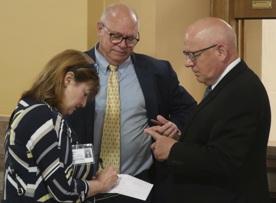 Acting Kansas Corrections Secretary Chuck Simmons, right, confers with recently retired Interim Secretary Roger Werholtz, center, and Jeanny Sharp, the Department of Corrections' spokeswoman, after a meeting of Gov. Laura Kelly and legislative leaders, Wednesday, June 5, 2019, at the Statehouse in Topeka, Kansas. Republican legislative leaders blocked nearly $10 million in planned spending by the department in the next state budget.(AP Photo/John Hanna)