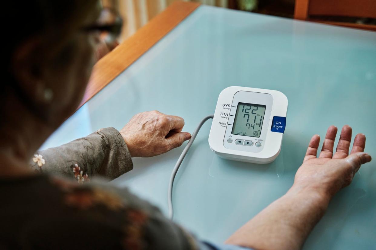 senior woman examining her blood pressure on her arm