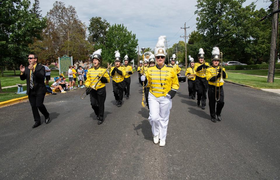 Adrian College's Marching Band and director, Ryan Cupp (left), participate in the Bulldogs' homecoming parade Sept. 16, 2023, along Madison Street.