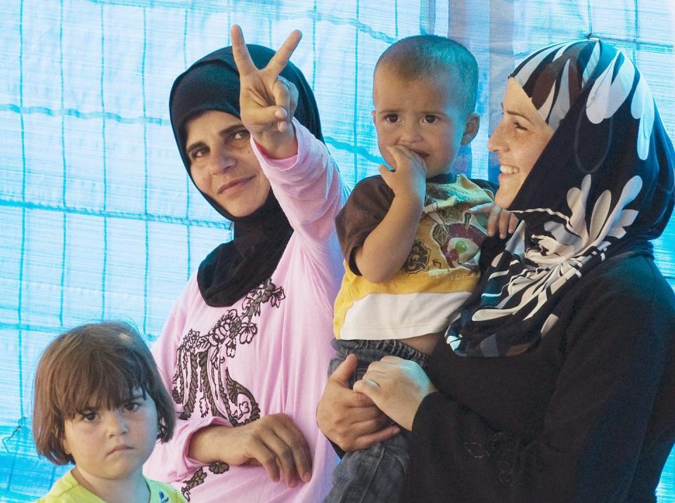 Syrian refugee women react as they wait with their children outside a makeshift hospital in a refugee camp in the Turkish town of Yayladagi in June 2011. (AP Photo/Burhan Ozbilici)