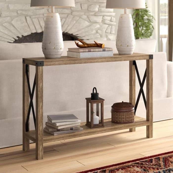 A wooden table in a home with books and baskets stored on it.