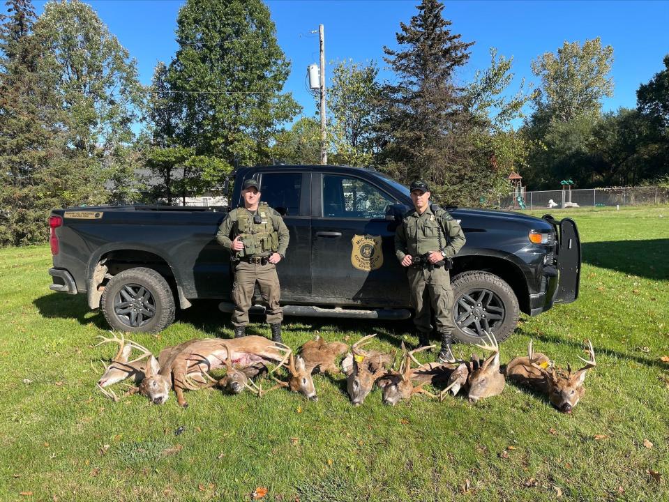 Michigan DNR Conservation Officers Tyler Cole, left, and Matt Page, right, seized nine poached trophy bucks from the possession of Justin Ernst, 33, of Decatur last October. Image provided by Michigan Department of Natural Resources.