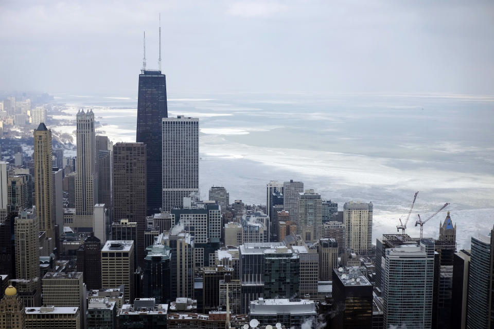 FILE - In this Feb. 17, 2015, file photo, ice covered Lake Michigan is seen behind downtown skyline, in Chicago. Big cities, like Chicago, aren't growing like they used to. New figures released by the U.S. Census Bureau on Thursday, May 23, 2019, show most of the nation's largest cities last year grew by a fraction of the numbers they did earlier this decade. (AP Photo/Kiichiro Sato, File)