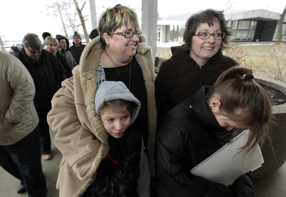 Jenny Stanczyk, rear at left, and Cheryl Pine, rear at right, wait in line to apply for a marriage license at the Oakland County Clerks office with Maria, front left, and Nina Stanczyk in Pontiac, Mich., Saturday, March 22, 2014. A federal judge has struck down Michigan's ban on gay marriage Friday the latest in a series of decisions overturning similar laws across the U.S. Some counties plan to issue marriage licenses to same-sex couples Saturday, less than 24 hours after a judge overturned Michigan's ban on gay marriage. (AP Photo/Paul Sancya)