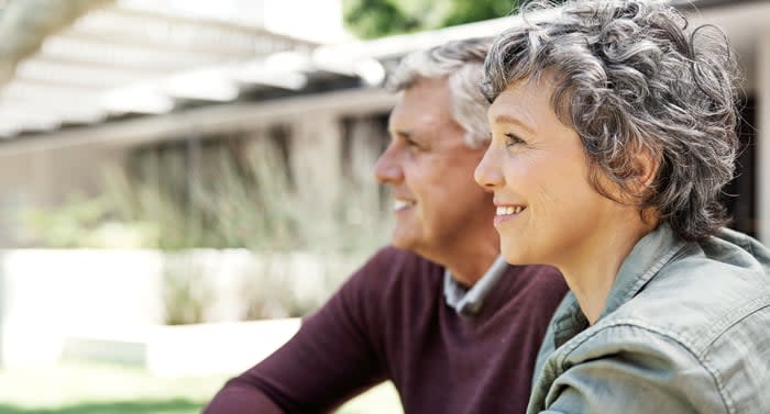 A couple is outdoors, looking into the distance.