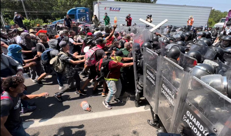 Los migrantes rompen una línea de Guardias Nacionales que intentan bloquear su salida de Tapachula, México, el viernes 1 de abril de 2022.