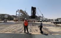 Workers are seen at the damaged site of Saudi Aramco oil facility in Khurais