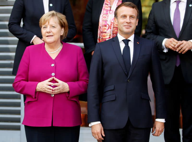 FILE PHOTO: French President Emmanuel Macron and German Chancellor Angela Merkel pose for a family photo during a joint Franco-German cabinet meeting in Toulouse