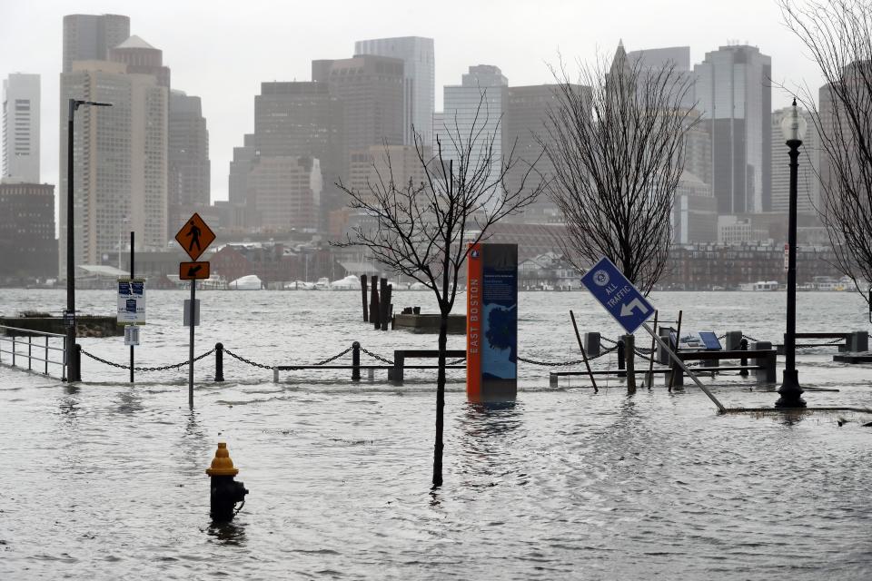 Water floods a street during high tide, Friday, Dec. 23, 2022, in the East Boston neighborhood of Boston. Winter weather is blanketing the U.S. More than 200 million people — about 60% of the U.S. population — were under some form of winter weather advisory or warning on Friday. (AP Photo/Michael Dwyer)