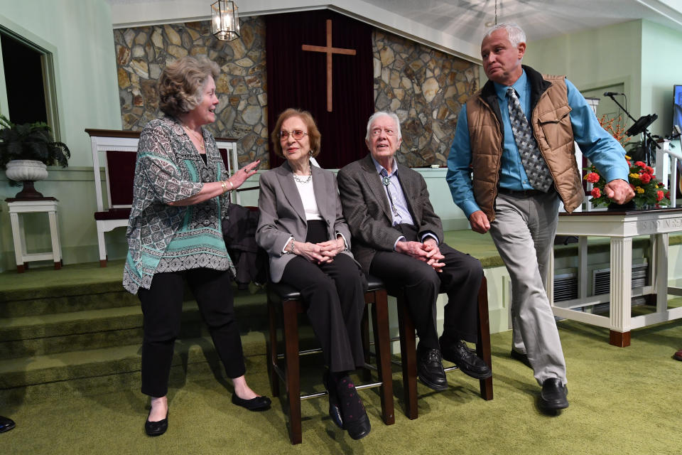 In this Nov. 3, 2019, photo, former President Jimmy Carter, second from right, and former first lady Rosalynn Carter sit, as guests Romona Kluth, left, and husband Doug Kluth, from Nebraska, finish their turn of having their photo made with them, after Sunday school at the Maranatha Baptist Church, in Plains, Ga. (AP Photo/John Amis)