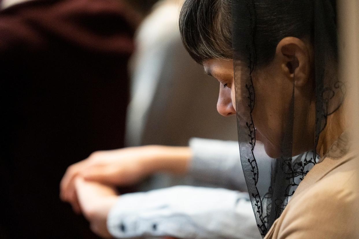 Feb 19, 2023; Galloway, OH, USA; Natasha Meleshchuk bows her head during prayer at Grace Evangelical Church. The church which conducts services in Ukrainian, has become a hub for refugees.