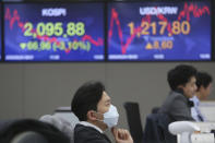 A currency trader wears a face mask as he watches monitors at the foreign exchange dealing room of the KEB Hana Bank headquarters in Seoul, South Korea, Monday, Feb. 24, 2020. (AP Photo/Ahn Young-joon)